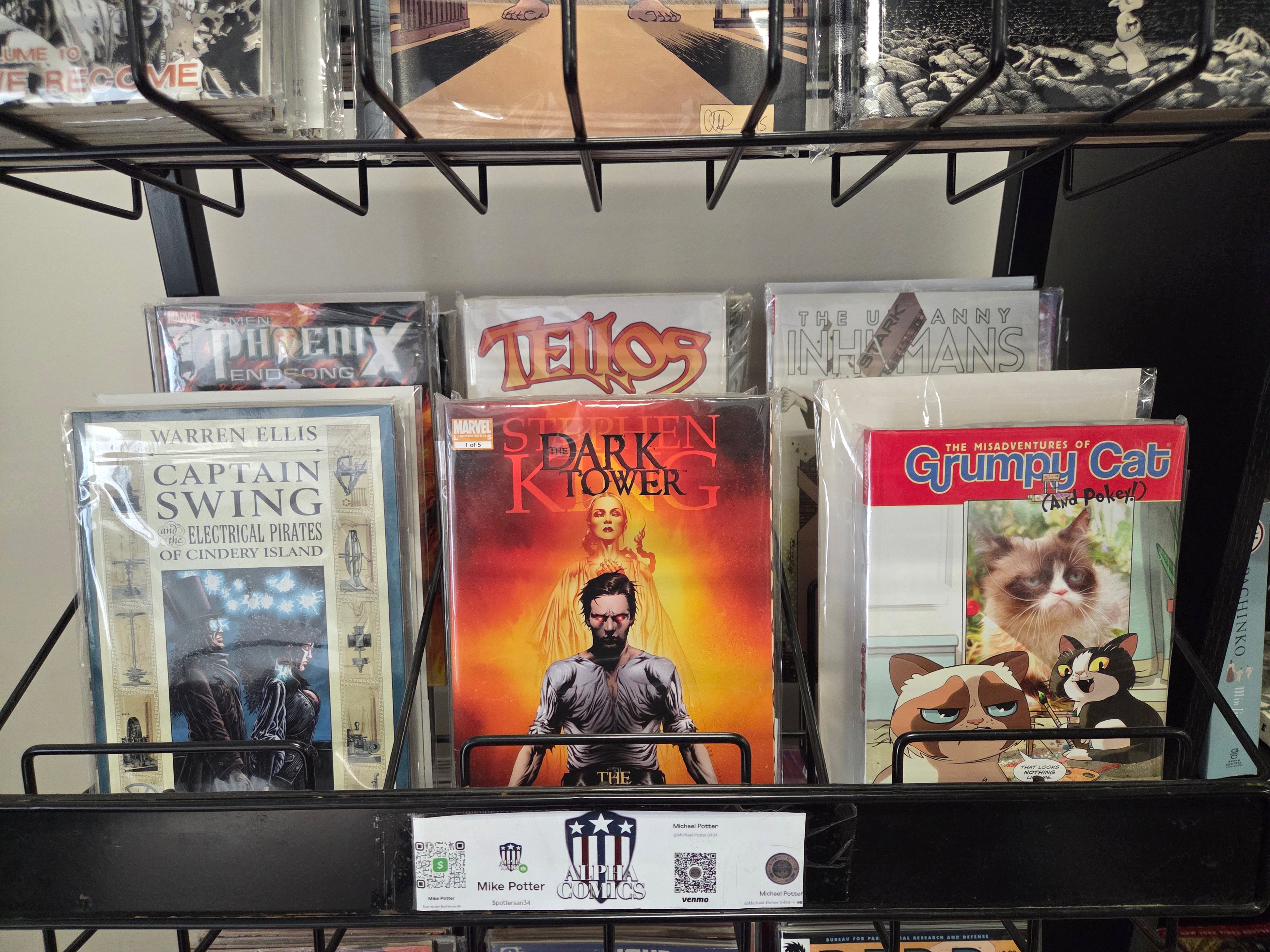 Collection of comic books on a display rack with 'Dark Tower' and 'Grumpy Cat' covers.