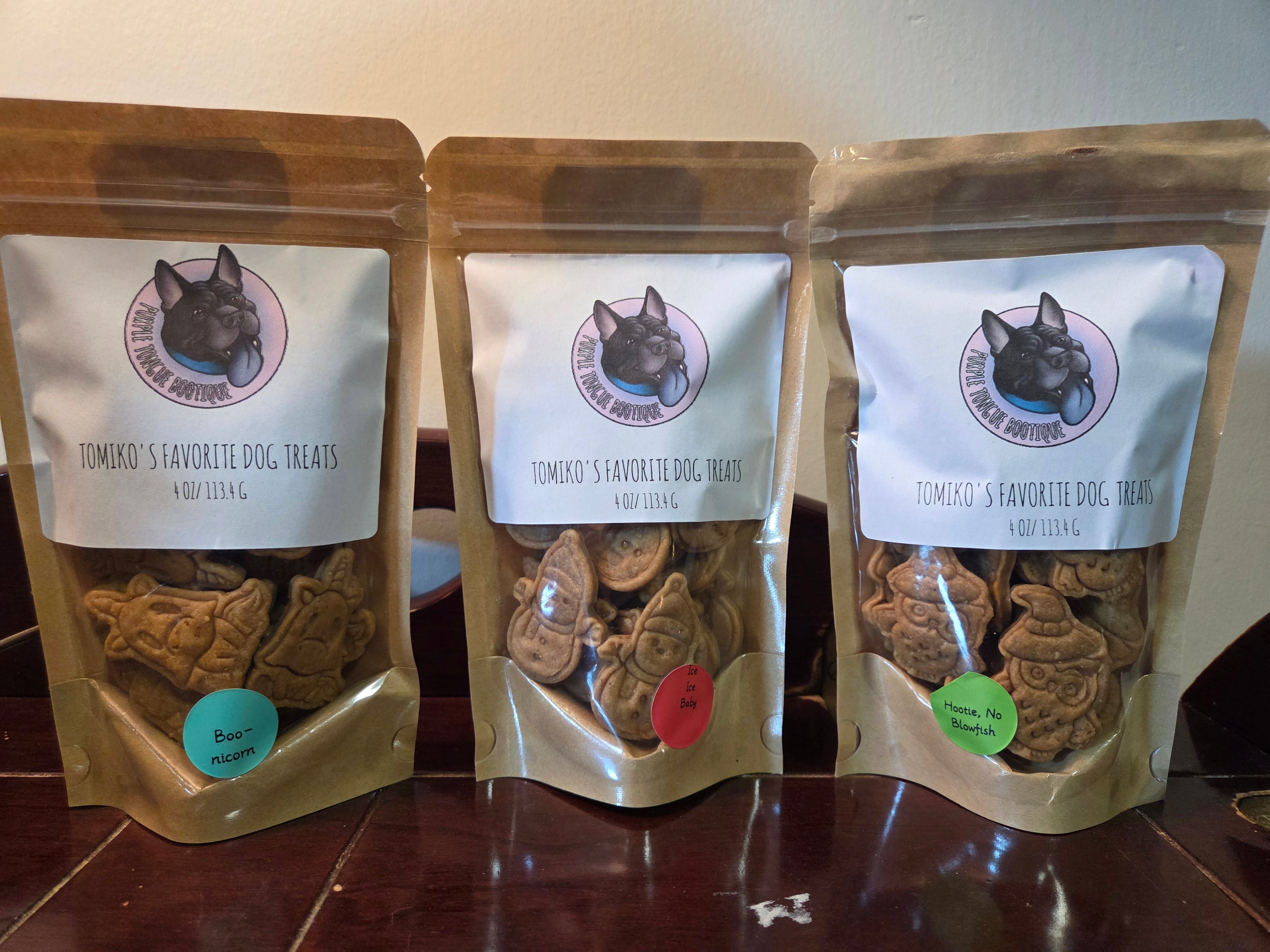 Three packages of dog treats with visible branding on a wooden surface.