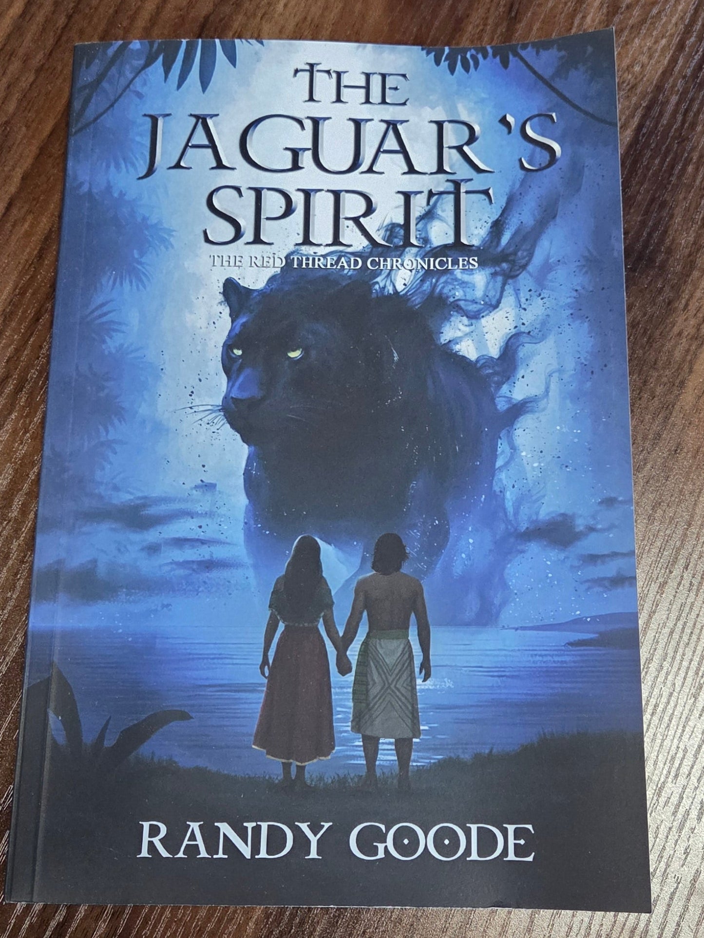 Book titled "The Jaguar's Spirit" by Randy Goode on brown background. 