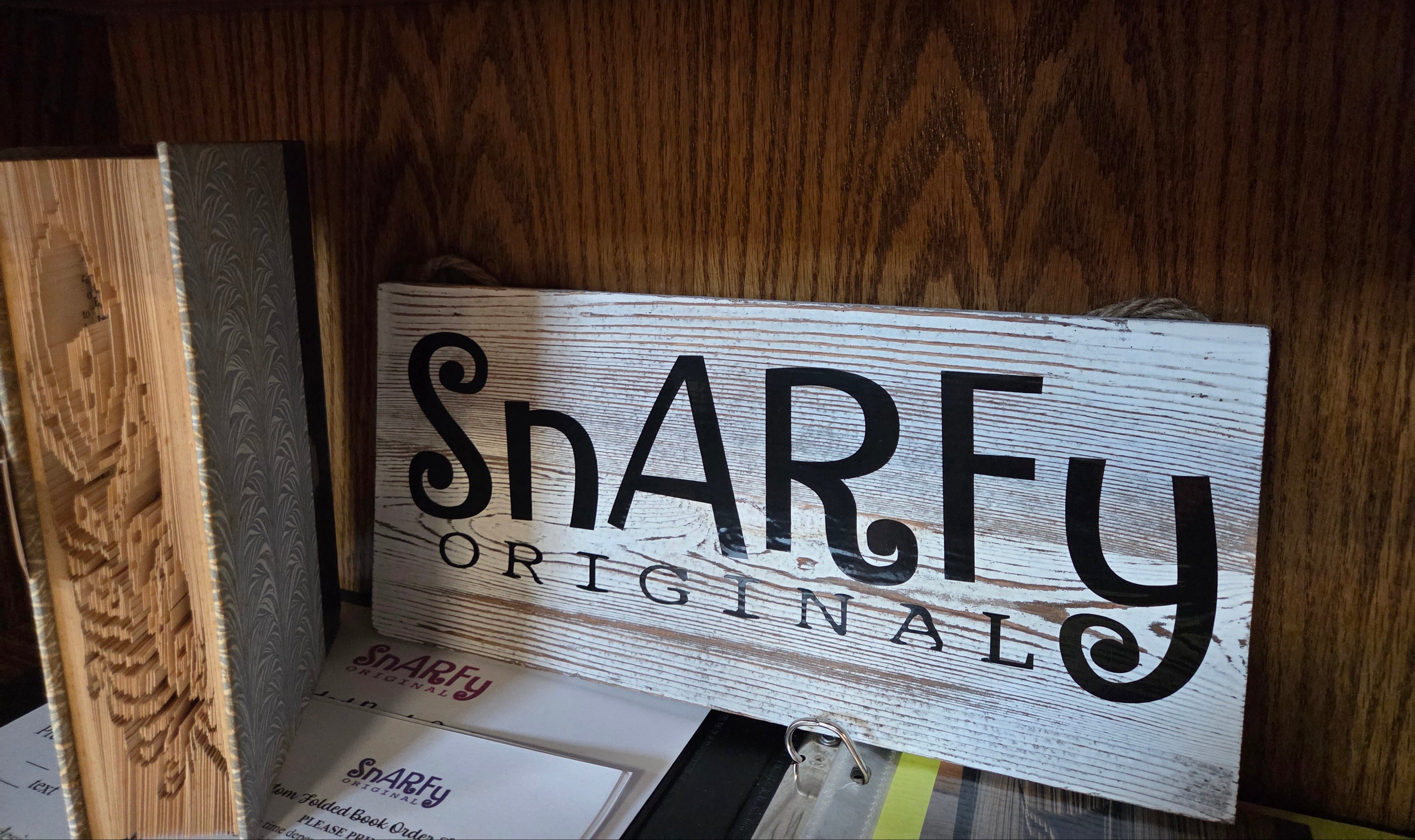 Snarfy company named on sign with book depicting a feather folded into the pages beside it