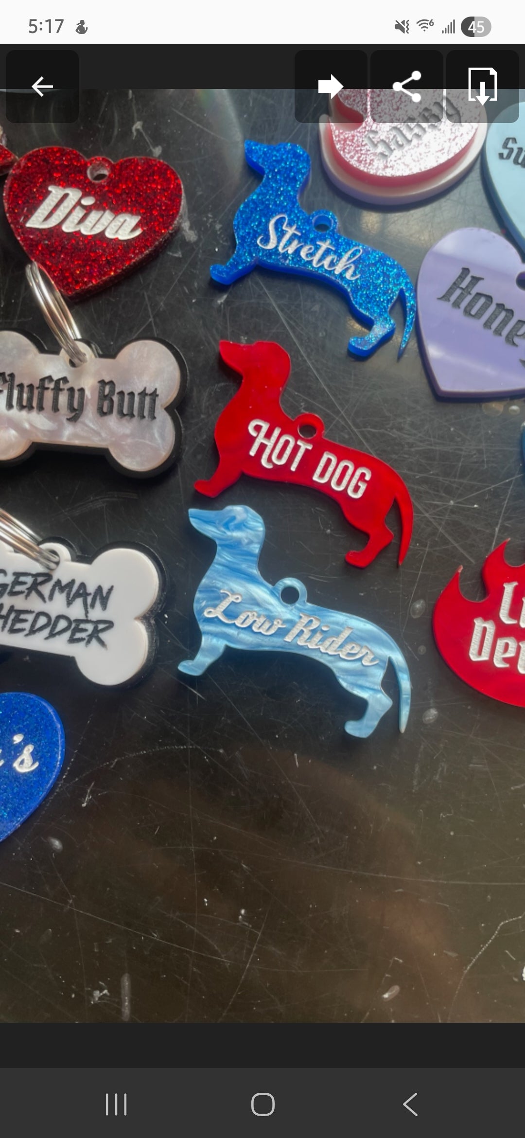 Collection of colorful pet tags on a dark surface